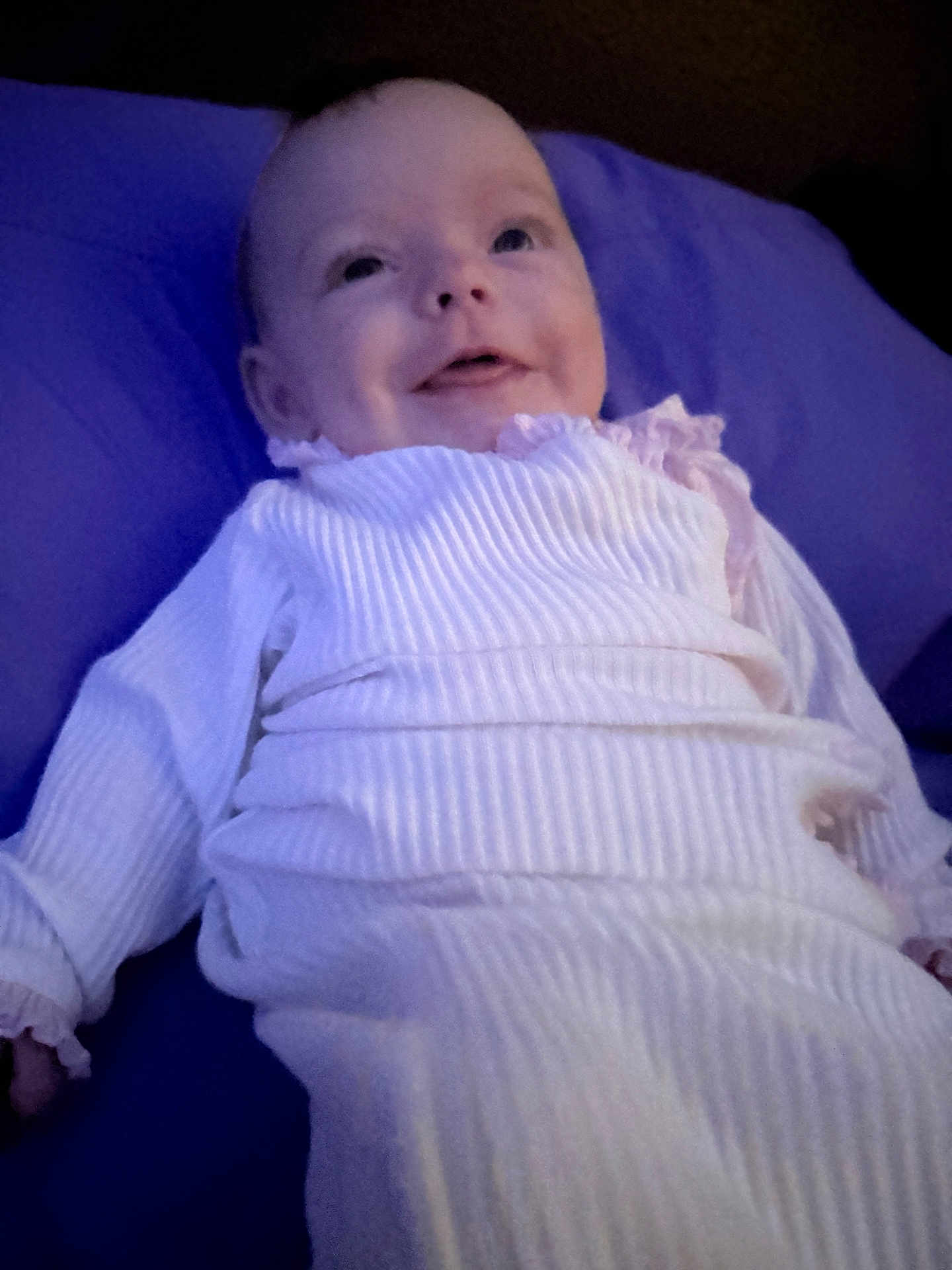 Wrenly is registered to the contest to win money with this photo: baby, infant, smile, lying_down, onesie, pillow, blanket, portrait, indoors, cute, cheeks, eyes, hands, fabric, soft_lighting, bed, gown, newborn, happy, head