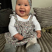 Alba a rejoint le concours — aidez-le/la à gagner de superbes lots ! baby, child, smiling, happy, headband, dress, couch, pillow, indoor, cute, infant, sitting, portrait, clothing, face, person, cozy, texture, comfort, joy