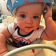 Joey is registered to the contest to win money with this photo: baby, child, hat, blue_hat, face, eyes, arm, hand, infant, cute, indoors, toy, clothing, smile, closeup, person, playful, curious, chubby, soft_lighting