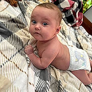 Adalaide is registered to the contest to win money with this photo: baby, infant, diaper, blanket, plaid, bed, face, blue_eyes, skin, cute, child, tummy_time, expression, indoor, person, young, newborn, soft, resting, curious