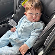 Noah is registered to the contest to win money with this photo: baby, child, car_seat, seatbelt, blue_onesie, infant, hand, face, hair, car_interior, safety, child_safety_seat, clothing, young_child, portrait, cute, serious_expression, person, indoors, seat