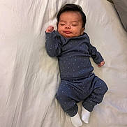 Ezra is registered to the contest to win money with this photo: baby, sleeping, pajamas, blue_clothing, infant, bed, blanket, white, face, hands, feet, socks, cute, resting, child, indoors, soft_light, comfortable, peaceful, portrait