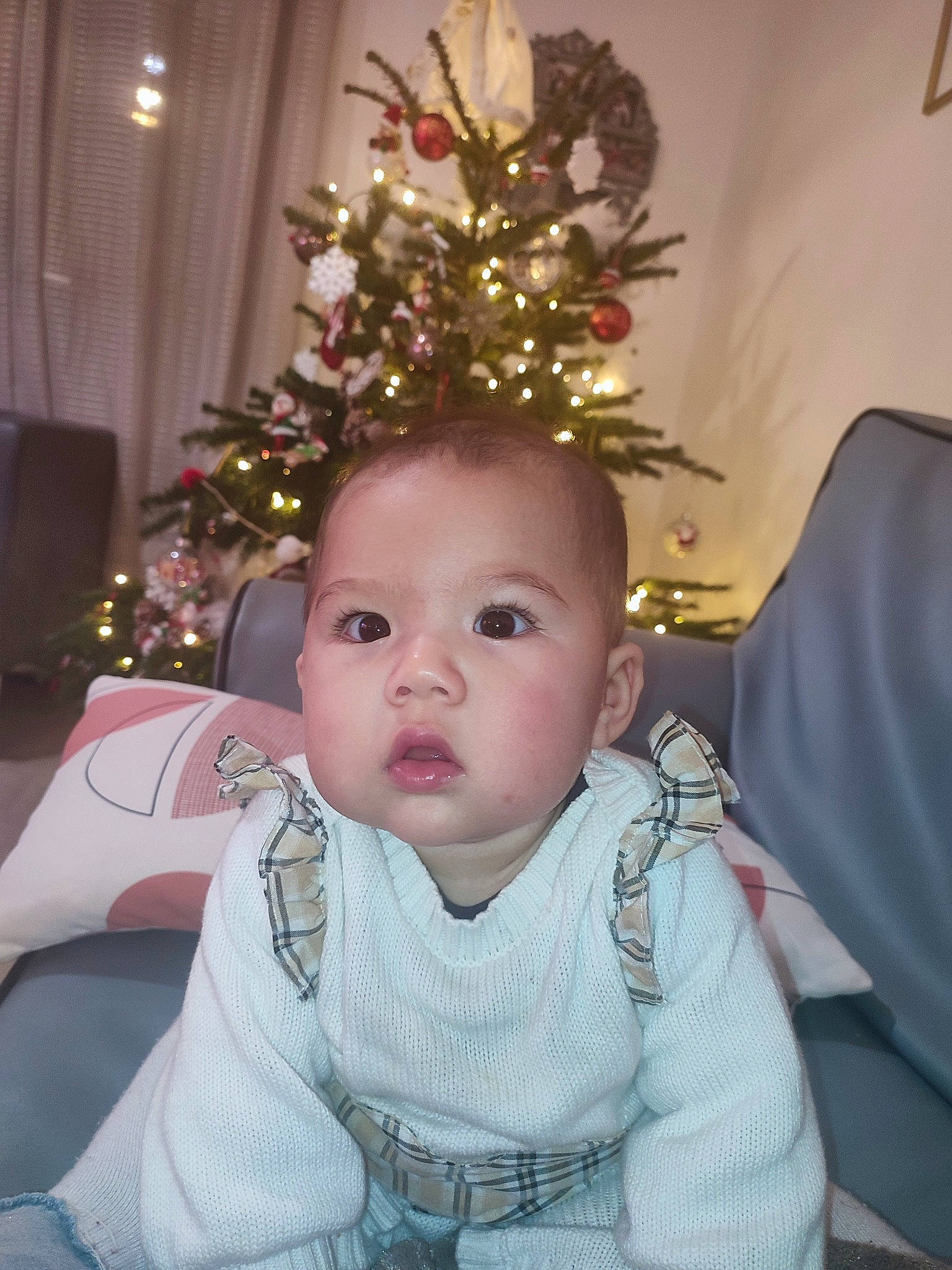 Estella participe au concours pour gagner de l'argent avec cette photo : baby, baby_toddler_clothing, chair, cheek, child, christmas, christmas_decoration, christmas_ornament, christmas_tree, event, happy, holiday, holiday_ornament, human_body, iris, lap, ornament, person, plant, sitting