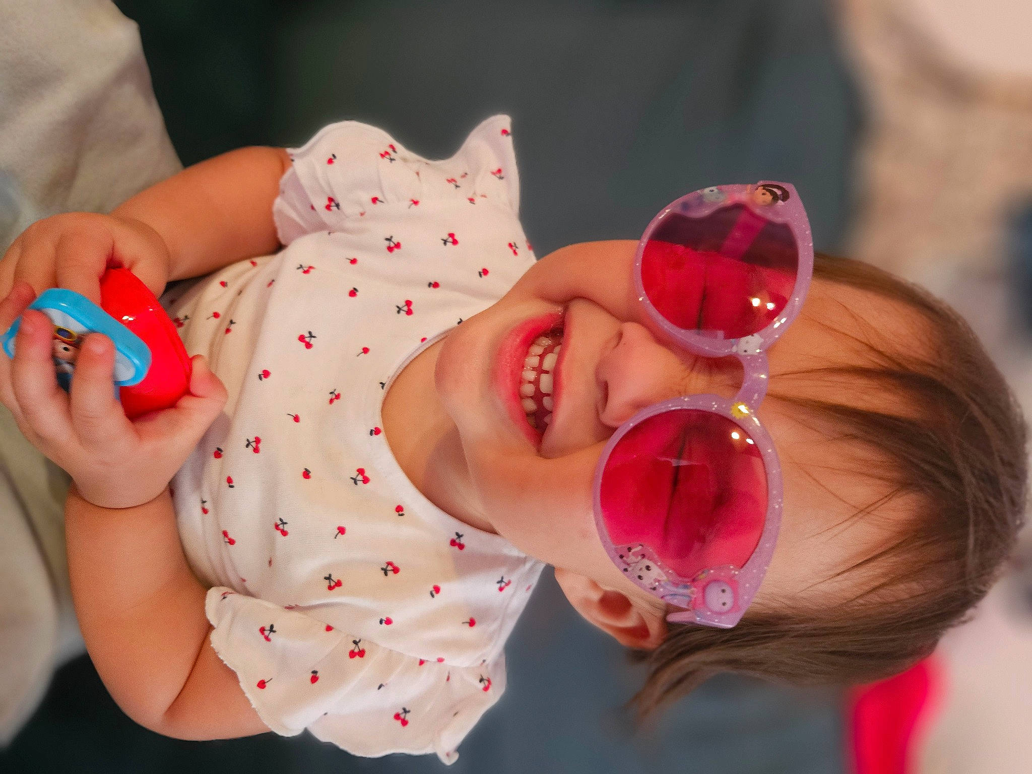 Estella participe au concours pour gagner de l'argent avec cette photo : baby, baby_products, baby_toddler_clothing, child, eyewear, finger, glasses, goggles, hand, happy, hat, joy, nail, pattern, person, pink, red, skin, smile, sunglasses
