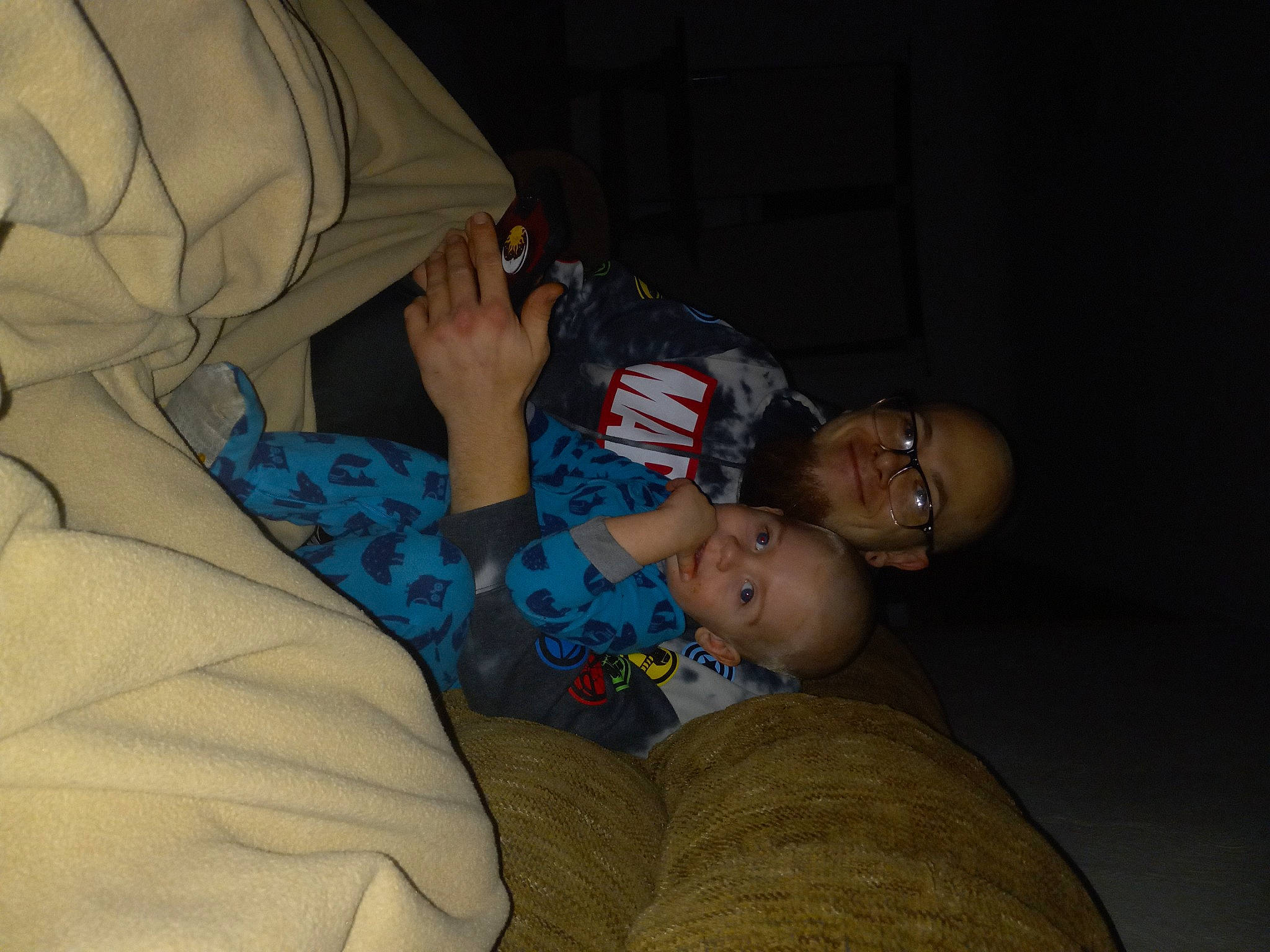 Enzo is registered to the contest to win money with this photo: baby, child, comfort, couch, darkness, elbow, event, finger, fun, glasses, interaction, joint, joy, lap, mouth, nose, person, sitting, skin, thigh