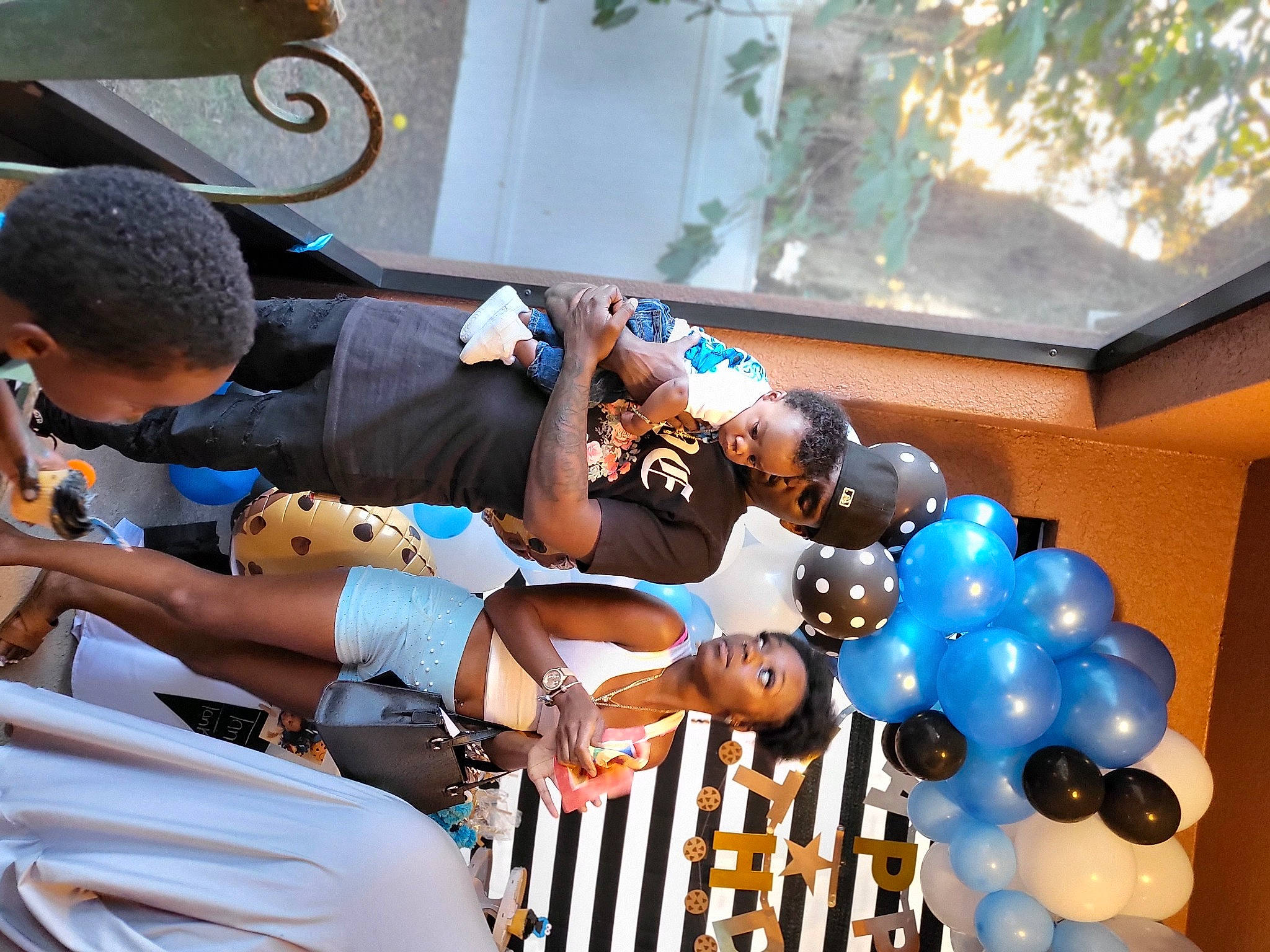 Markis is registered to the contest to win money with this photo: balloon, ceremony, child, elbow, electric_blue, event, fun, happy, hat, human_leg, leisure, light, party_supply, person, plant, room, shorts, sunglasses, thigh, toy