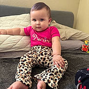Juliet joined the competition — help win amazing prizes! baby, child, infant, sitting, carpet, pink_shirt, leopard_print_pants, barefoot, indoor, pillows, soft_toys, cute, confident, face, hand, foot, home, room, young_child, portrait