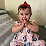 baby, child, girl, red_bow, headband, minnie_mouse, dress, clothing, smiling, happy, sitting, couch, blanket, indoor, portrait, cute, hands, face, playful, infant