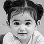 child, toddler, face, portrait, black_and_white, smile, hair_buns, curly_hair, cute, eyes, young_child, innocence, expression, head_and_shoulders, looking_at_camera, monochrome, person, indoors, soft_light, close_up