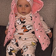 Rosalia participe au concours pour gagner de l'argent avec cette photo : toddler, child, pink_bow, headband, pink_jacket, minnie_mouse, cartoon_clothing, sneakers, white_shoes, couch, indoor, seated, cute, baby, fashion, clothing, portrait, face, person, cozy