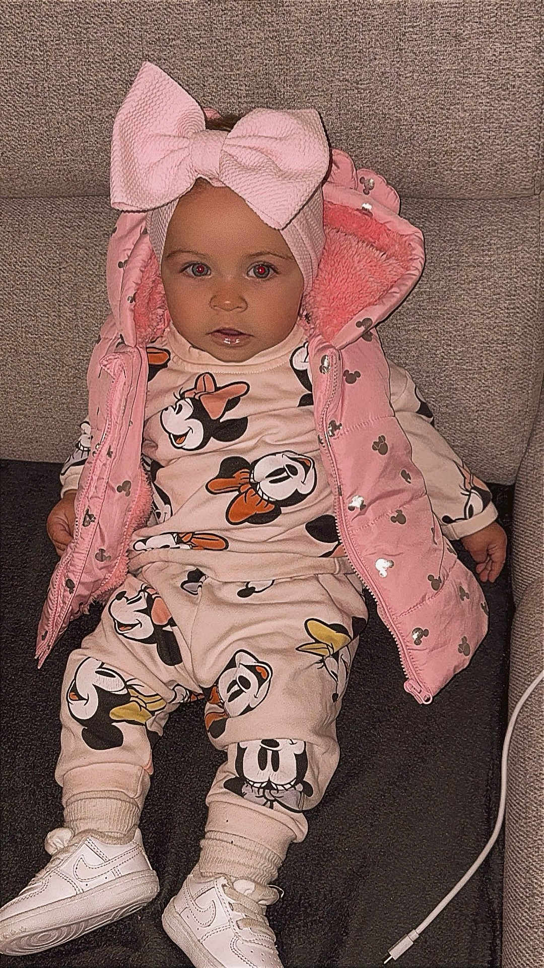 Rosalia participe au concours pour gagner de l'argent avec cette photo : toddler, child, pink_bow, headband, pink_jacket, minnie_mouse, cartoon_clothing, sneakers, white_shoes, couch, indoor, seated, cute, baby, fashion, clothing, portrait, face, person, cozy