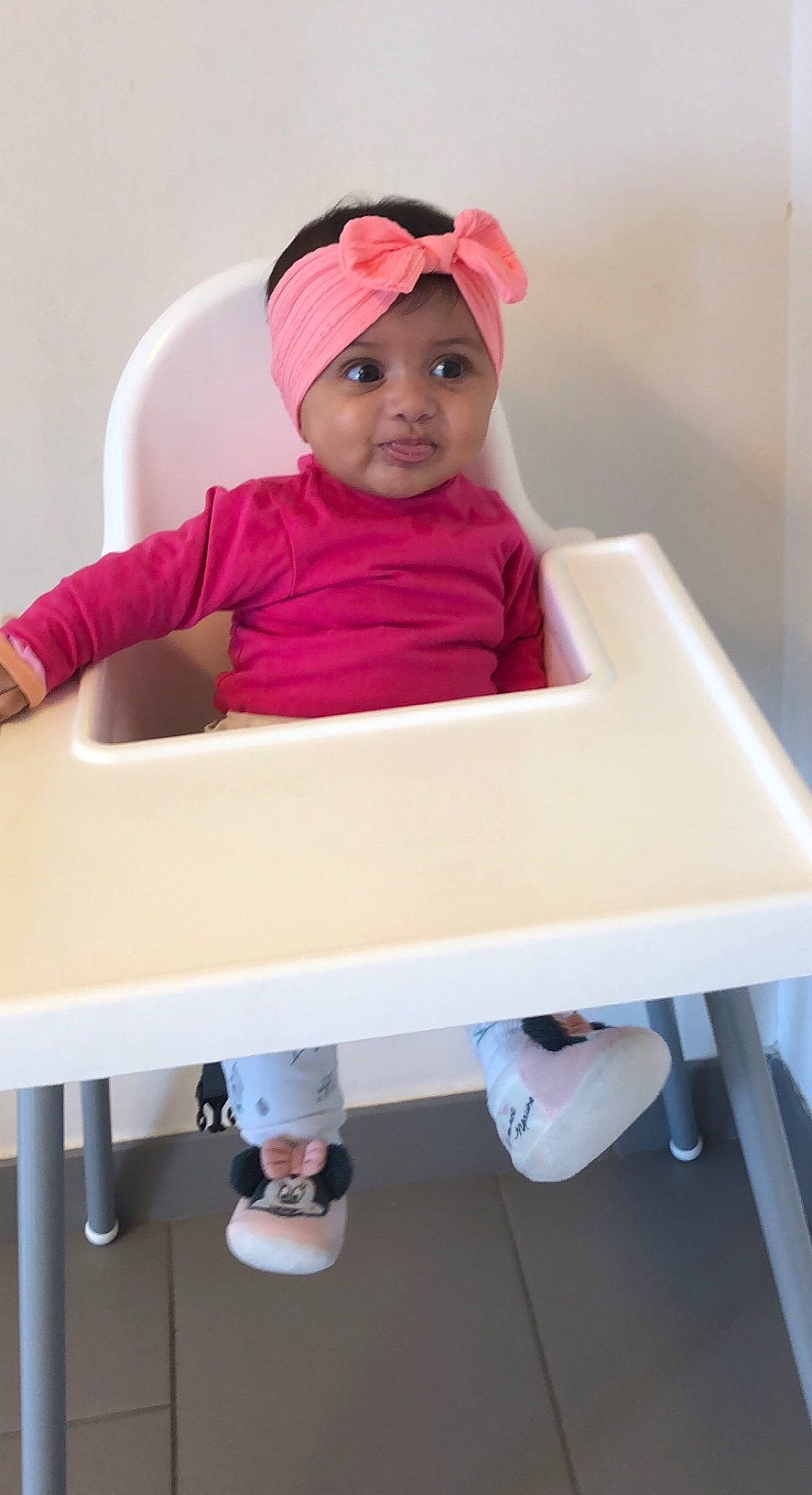 Mélya a rejoint le concours — aidez-le/la à gagner de superbes lots ! baby, baby_toddler_clothing, cap, child, comfort, footwear, headgear, headwear, magenta, person, pink, red, room, shoe, sitting, sleeve, sneakers, t_shirt, table, toddler