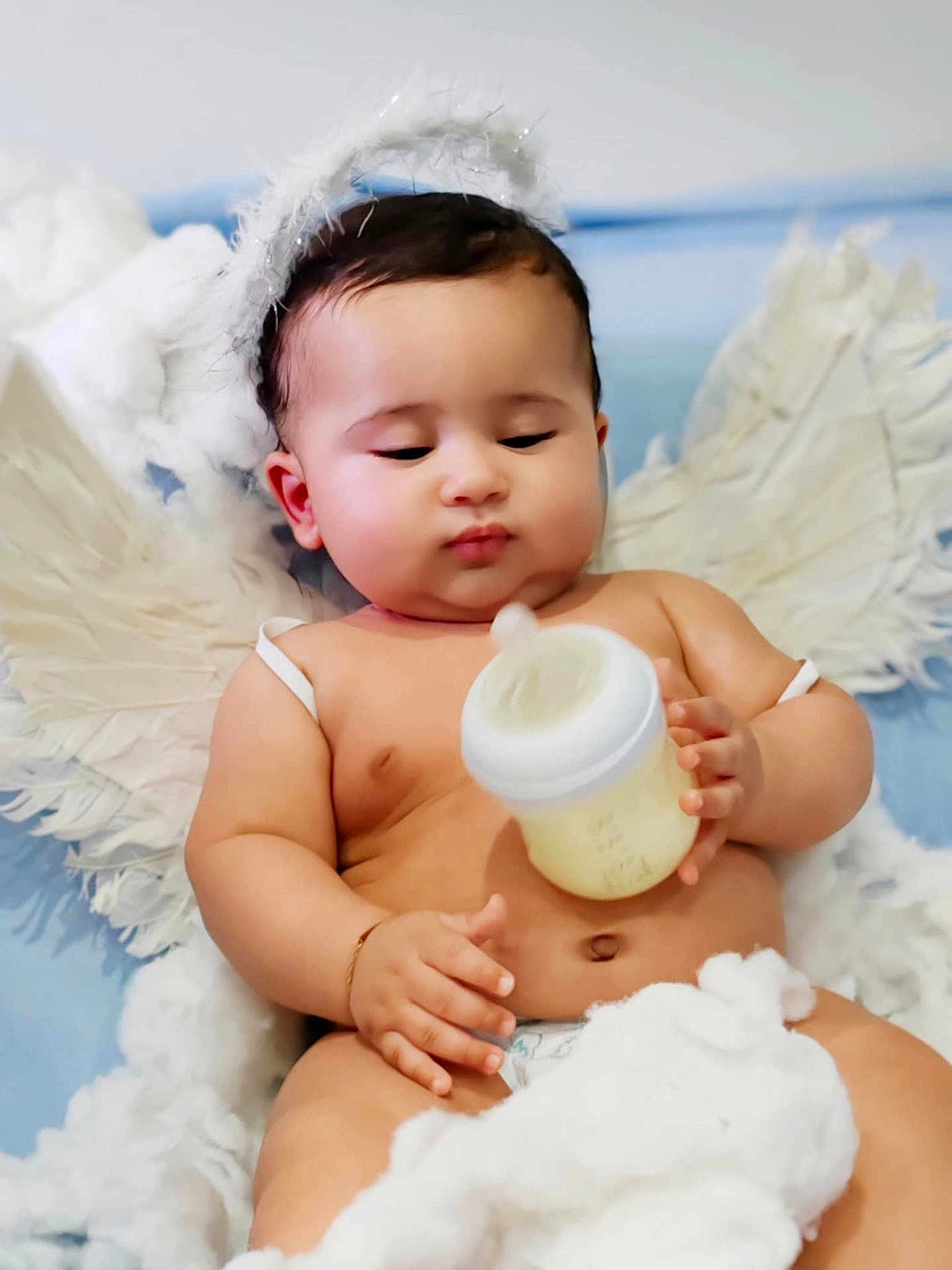 Ywan a rejoint le concours — aidez-le/la à gagner de superbes lots ! adorable, angel, baby, blue_background, child, chubby, closeup, clouds, cute, diaper, halo, indoors, infant, milk_bottle, peaceful, portrait, sleepy, soft, white, wings