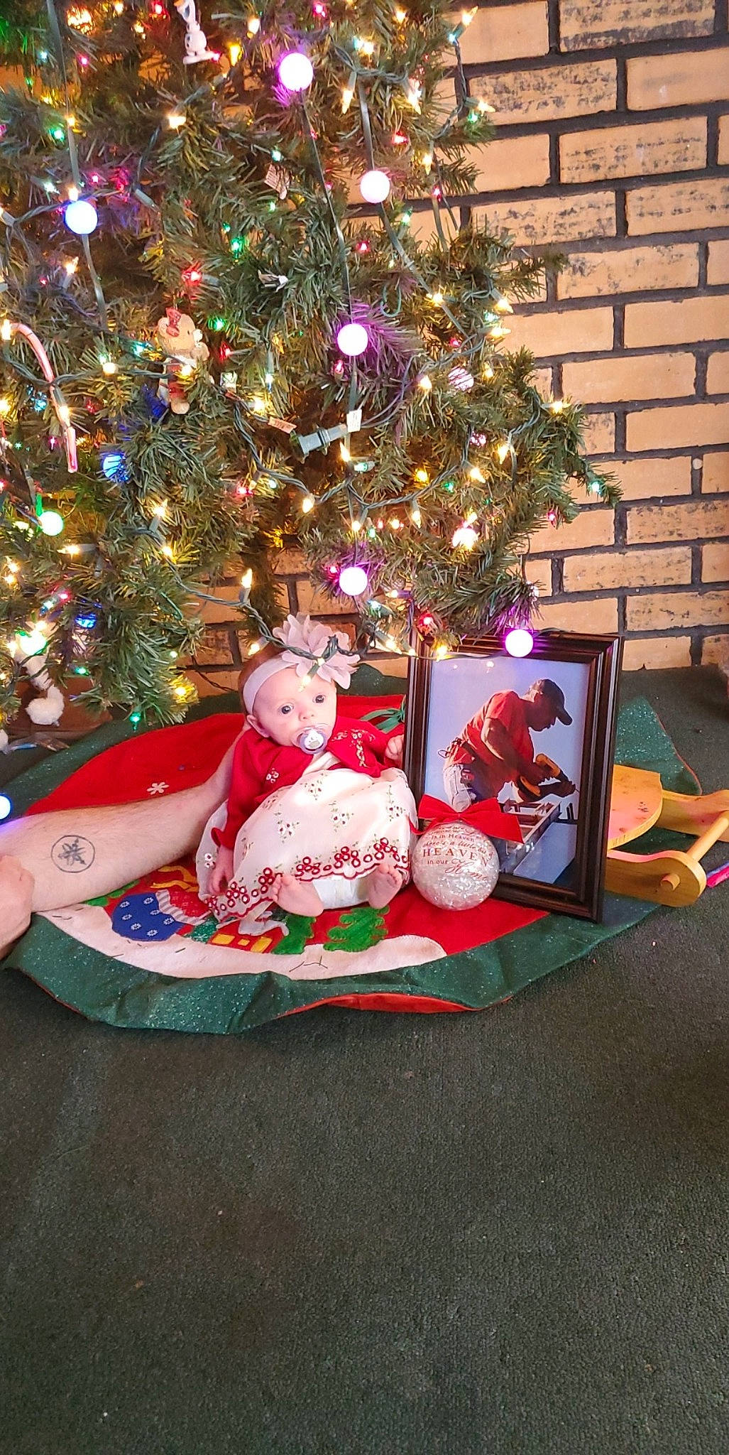 Ensleigh is registered to the contest to win money with this photo: christmas, christmas_decoration, christmas_eve, christmas_ornament, christmas_tree, event, fir, holiday, holiday_ornament, interior_design, lap, ornament, person, sitting, toddler, tree
