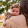 baby, infant, child, parent, portrait, outdoor, garden, bokeh, smiling, wide_eyed, headband, bow, dress, ruffles, lace, shoulder, hugging, family, nature, photography