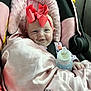baby, car_seat, pink_blanket, pink_bow, bottle, infant, happy, child, seatbelt, car_interior, cozy, smiling, headband, cute, wrapped, toddler, person, indoors, soft_texture, blanket
