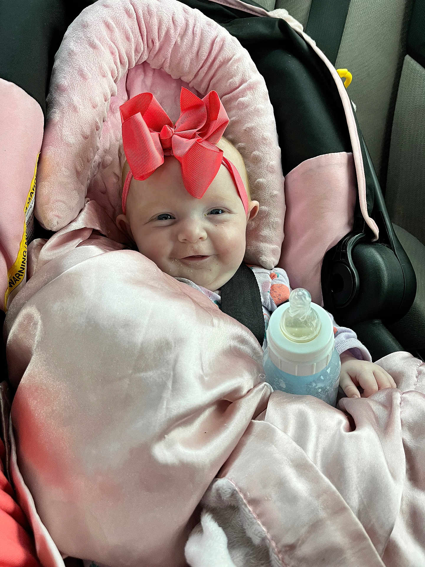 Haylen is registered to the contest to win money with this photo: baby, car_seat, pink_blanket, pink_bow, bottle, infant, happy, child, seatbelt, car_interior, cozy, smiling, headband, cute, wrapped, toddler, person, indoors, soft_texture, blanket