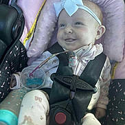 Haylen is registered to the contest to win money with this photo: baby, infant, car_seat, child, smiling, bow, headband, pacifier, seatbelt, pink, clothing, cute, happy, baby_girl, sitting, indoors, soft_lighting, fabric, pattern, safety