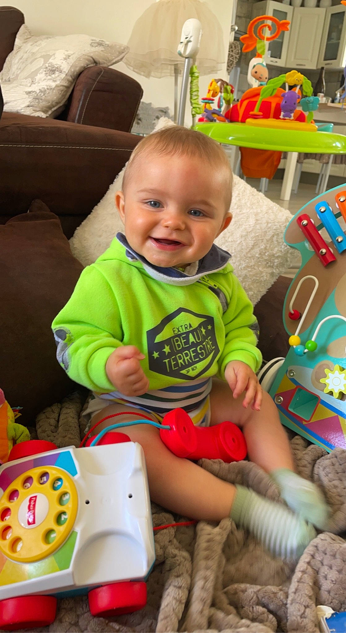 Achille a rejoint le concours — aidez-le/la à gagner de superbes lots ! baby, baby_playing_with_toys, baby_toddler_clothing, face, facial_expression, fun, green, happy, head, human_body, iris, joy, mammal, organ, person, photograph, product, skin, smile, standing