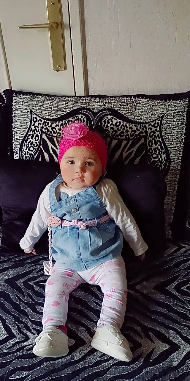 Bayen participe au concours pour gagner de l'argent avec cette photo : baby, baby_products, baby_toddler_clothing, child, comfort, couch, eye, flooring, fun, fur, head, headgear, headwear, linens, magenta, pattern, person, pink, purple, room
