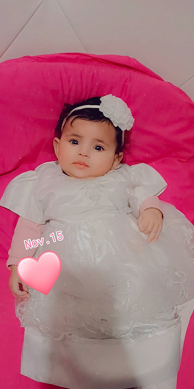 Bayen participe au concours pour gagner de l'argent avec cette photo : baby, baby_toddler_clothing, cheek, child, chin, comfort, dress, eyelash, face, facial_expression, fashion_accessory, head, lip, magenta, person, pink, sitting, skin, sleeve, toddler