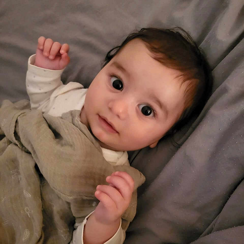Taym a rejoint le concours — aidez-le/la à gagner de superbes lots ! baby, bed, blanket, child, clothing, cozy, cute, expression, face, hand, indoors, infant, looking, lying_down, portrait, resting, skin, sleepwear, soft_texture, young