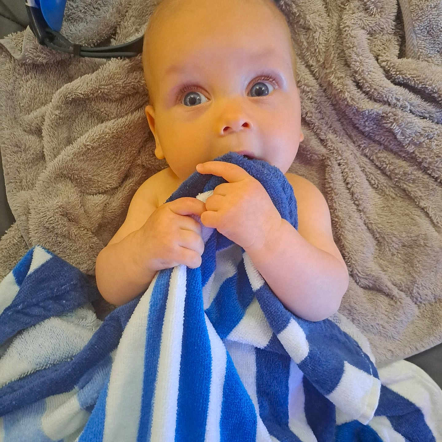 Billy is registered to the contest to win money with this photo: baby, blanket, blue, candid, child, comfort, cozy, curious, cute, face, hands, indoors, infant, portrait, skin, soft, striped, towel, white, wide_eyes