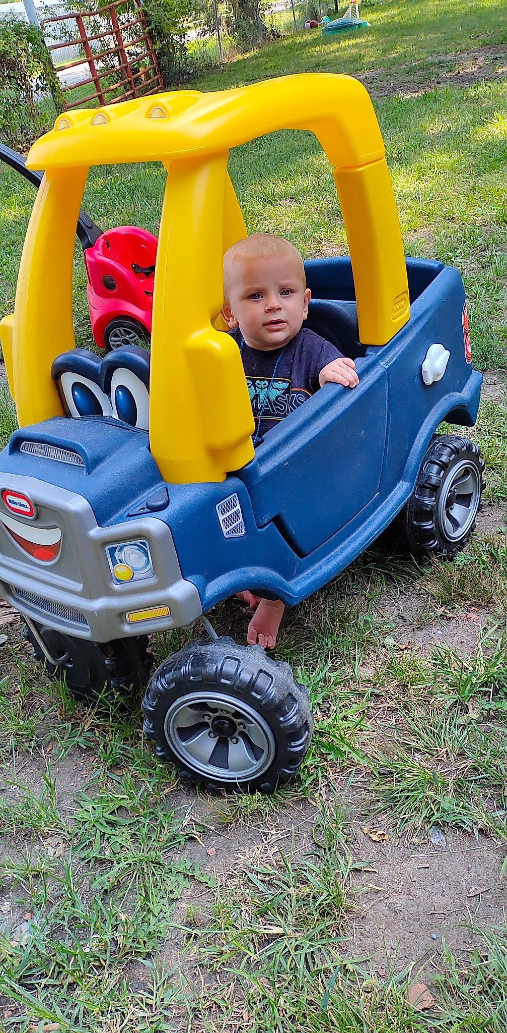 Wesley is registered to the contest to win money with this photo: automotive_design, automotive_exterior, automotive_tire, baby, child, fender, grass, motor_vehicle, person, plant, recreation, riding_toy, rim, shorts, synthetic_rubber, tire, toddler, tread, vehicle, wheel