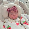 Elena is registered to the contest to win money with this photo: baby, sleeping, infant, portrait, indoors, bassinet, blanket, strawberry, bow, headband, nursery, cushion, soft_lighting, cozy, peaceful, face, closed_eyes, sitting, baby_gear, home