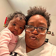 Aurora joined the competition — help win amazing prizes! baby, infant, adult, parent, selfie, portrait, face, smiling, duck_face, eyeglasses, curly_hair, pink_clothing, indoor, family, closeup, shoulder, home, wall, photographs, cozy