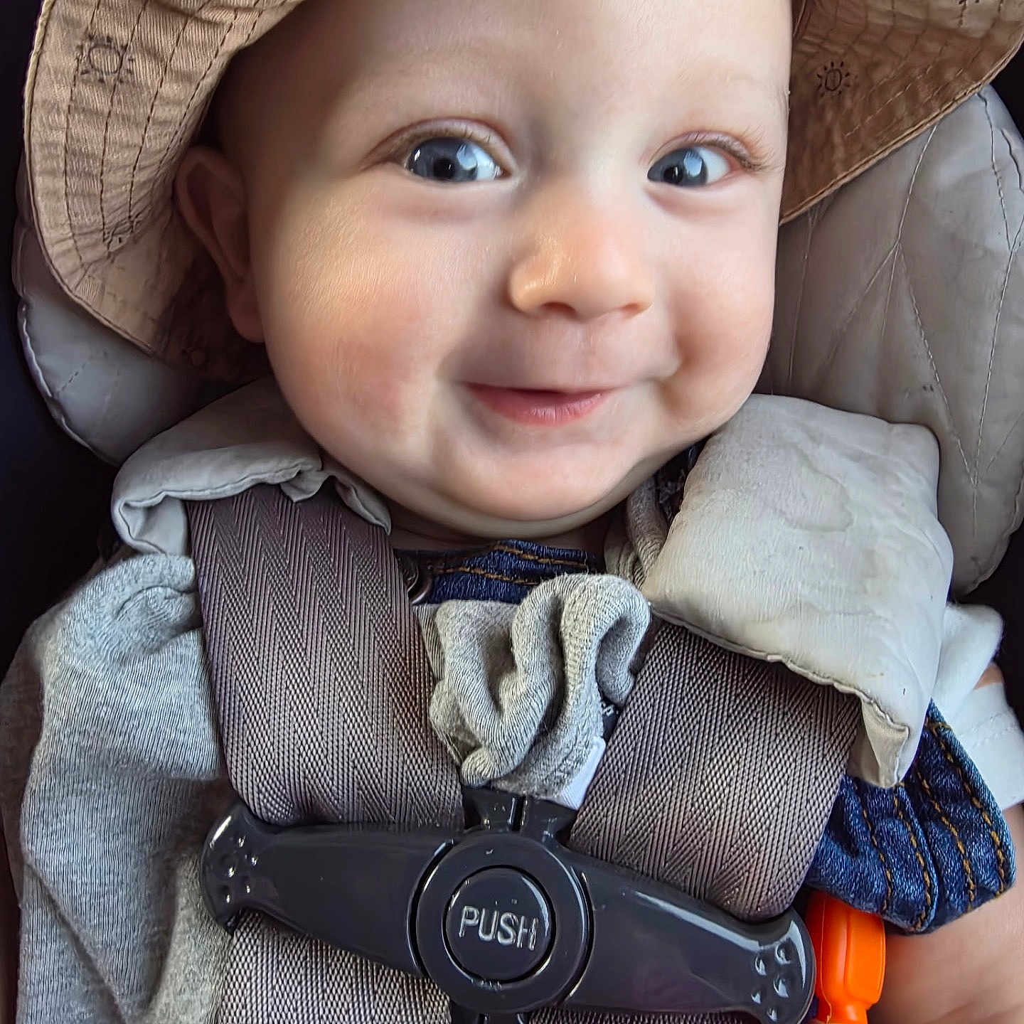 Blake joined the competition — help win amazing prizes! baby, child, smiling, face, hat, car_seat, seatbelt, clothing, infant, cute, happy, portrait, close_up, baby_toy, accessory, child_seat, straps, person, skin, headwear