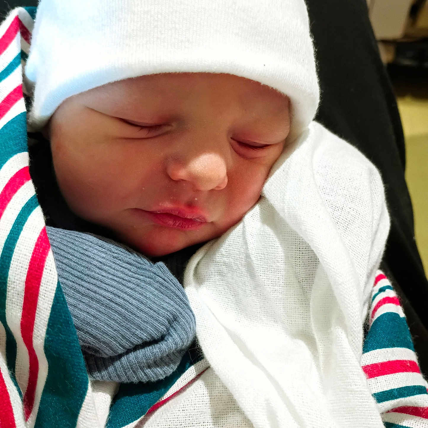 Weston joined the competition — help win amazing prizes! newborn, baby, sleeping, infant, portrait, face, white_hat, blanket, swaddled, wrapped, peaceful, indoors, close_up, soft_lighting, textile, striped_blanket, gray_clothing, nursery, resting, cute