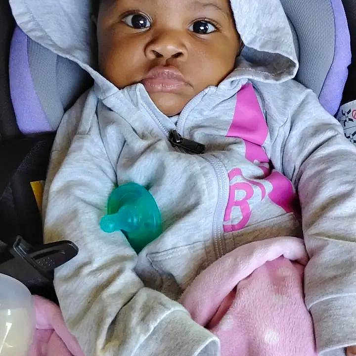 Delilah joined the competition — help win amazing prizes! baby, child, hoodie, blanket, car_seat, pacifier, pink, grey, polka_dot, clothing, portrait, infant, cute, indoors, seated, young_child, face, expression, warm, cozy