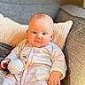 Albane participe au concours pour gagner de l'argent avec cette photo : baby, infant, child, pajamas, toy, couch, cushion, indoor, portrait, smiling, comfortable, cozy, striped_clothing, hand, face, head, skin, person, home, relaxing