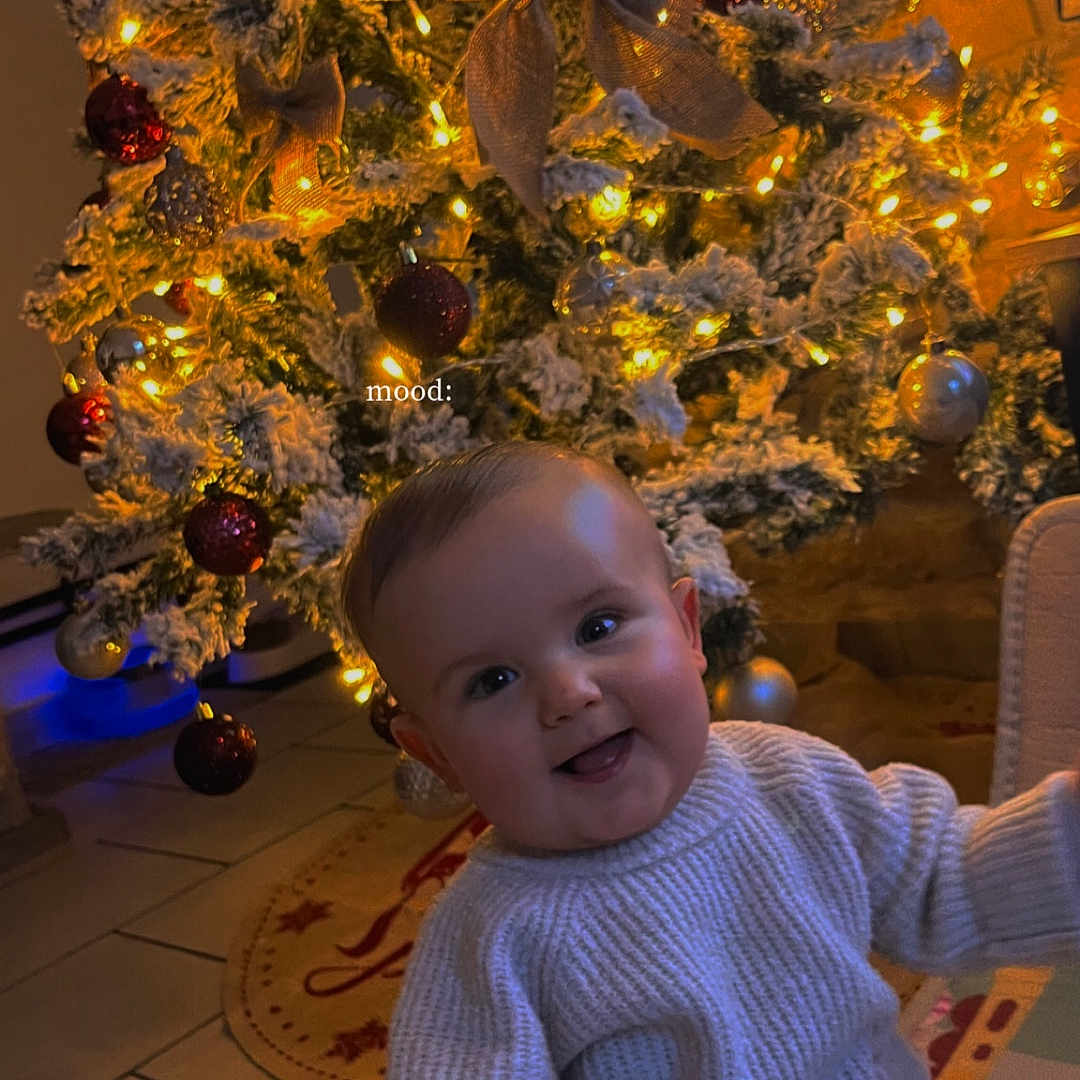 Khalys participe au concours pour gagner de l'argent avec cette photo : accessories, baby, bodypart, clothing, couch, face, finger, fir, furniture, hand, happy, head, knitwear, person, photography, plant, portrait, smile, sweater, tree