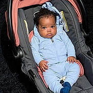 Truce joined the competition — help win amazing prizes! baby, infant, car_seat, blue_clothing, hoodie, socks, curly_hair, serious_expression, indoor, child, sitting, seat_belt, black_hair, dark_background, fabric, padded_seat, cute, portrait, person, young_child