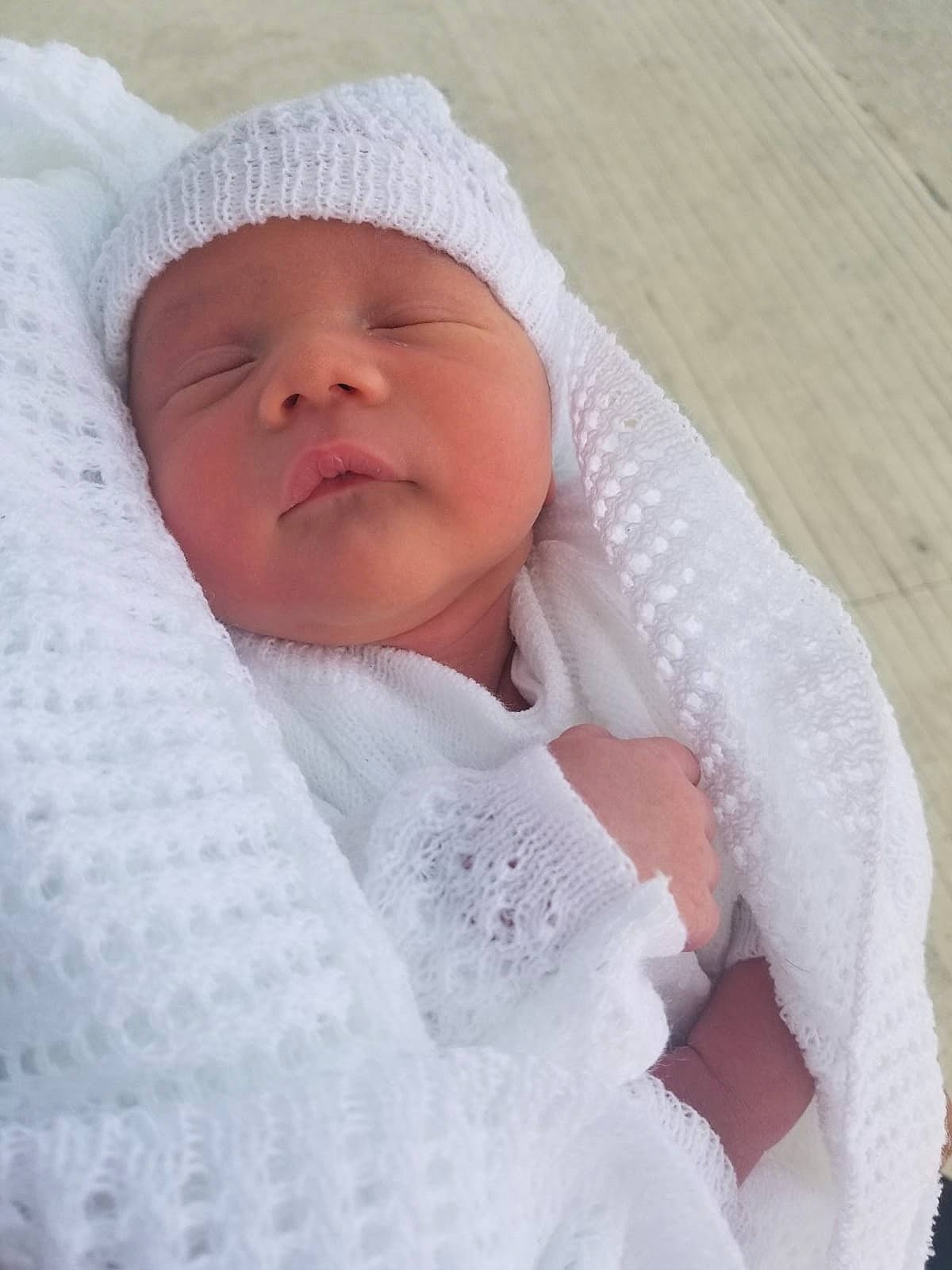 Derrek is registered to the contest to win money with this photo: blanket, bonnet, child, girl, headgear, infant, knitting, material, nose, person, product, skin, textile, toddler, wool