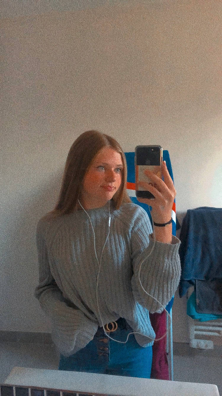 Lola participe au concours pour gagner de l'argent avec cette photo : abdomen, brown_hair, communication_device, elbow, electric_blue, flooring, gesture, happy, joint, long_hair, neck, person, portable_communications_device, shoulder, sitting, sleeve, thumb, trunk, waist, wood