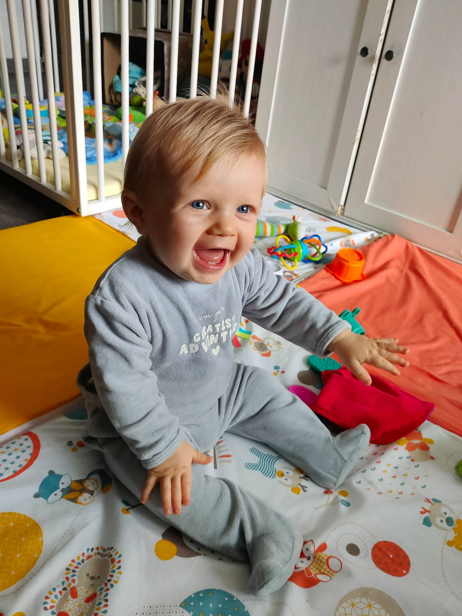 Gaël participe au concours pour gagner de l'argent avec cette photo : baby, baby_playing_with_toys, baby_toddler_clothing, child, comfort, door, flooring, fun, happy, head, orange, person, play, product, room, sitting, sleeve, smile, t_shirt, toddler