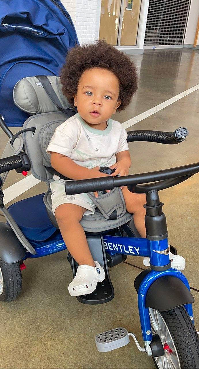 Sequan Quaziek is registered to the contest to win money with this photo: auto_part, automotive_tire, baby_carriage, bicycle, bicycle_tire, blue, child, comfort, electric_blue, human_leg, knee, mode_of_transport, person, recreation, riding_toy, snapshot, sneakers, tire, toddler, vehicle