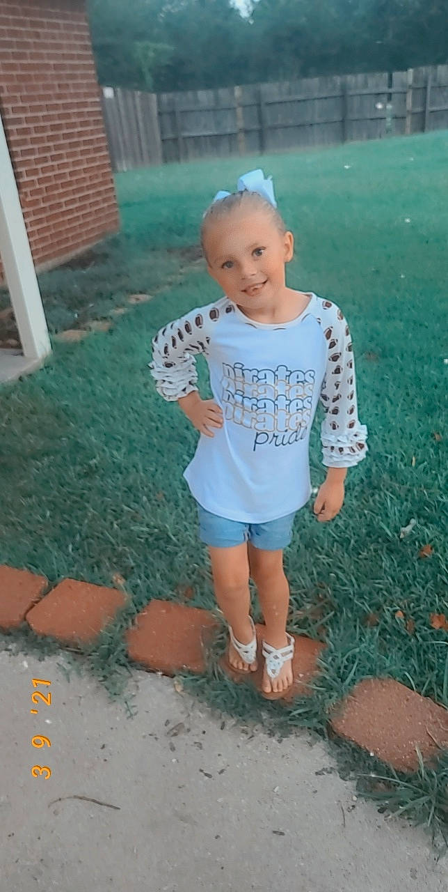 Lila is registered to the contest to win money with this photo: asphalt, baby_toddler_clothing, child, face, foot, fun, grass, happy, human_body, human_leg, joy, lawn, leisure, people_in_nature, person, recreation, shorts, sleeve, smile, t_shirt