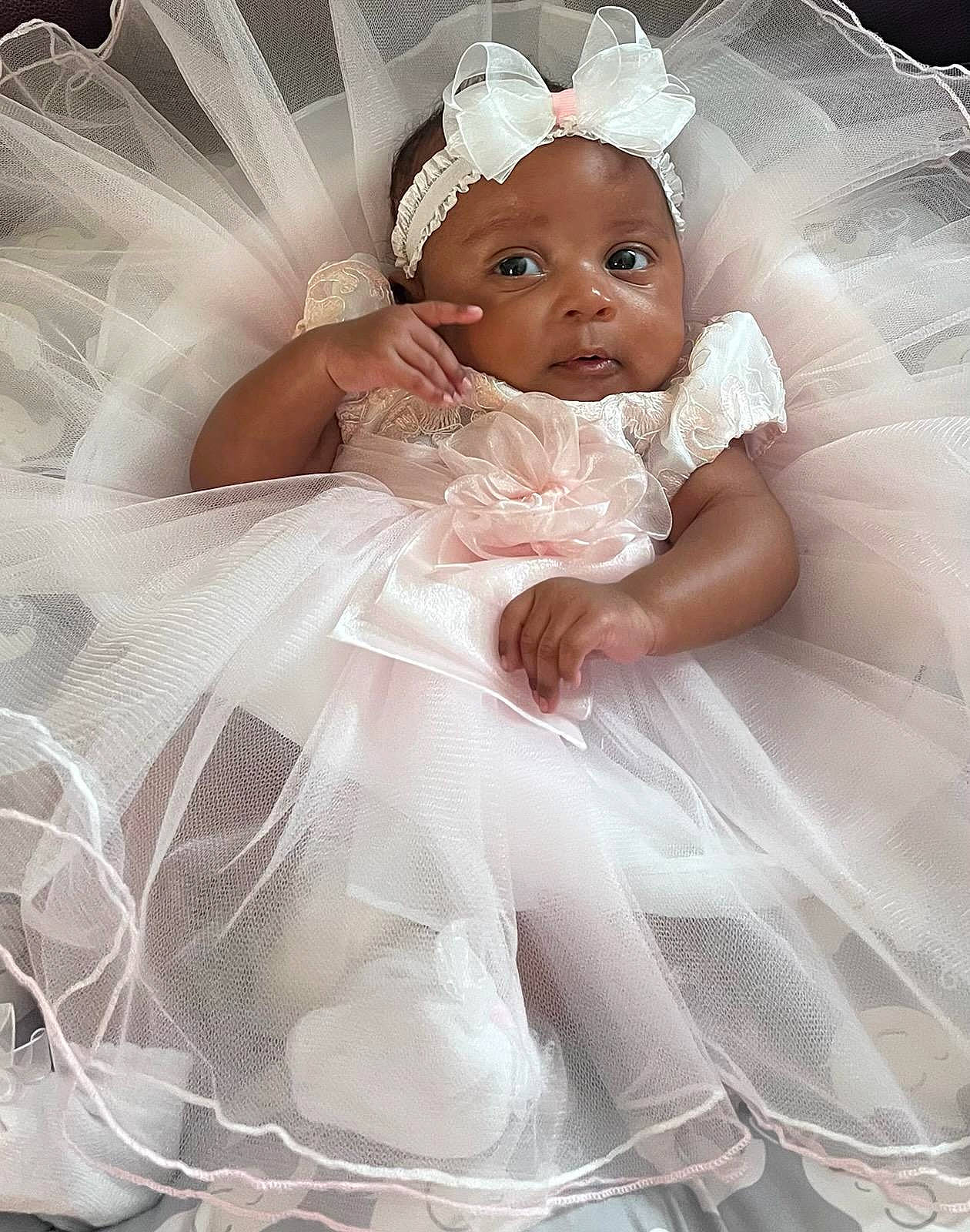 A'Zouri is registered to the contest to win money with this photo: arm, baby_toddler_clothing, bridal_clothing, dress, embellishment, eye, flash_photography, gown, hair, hand, happy, head, headgear, headwear, human_body, iris, leg, person, petal, picture_frame