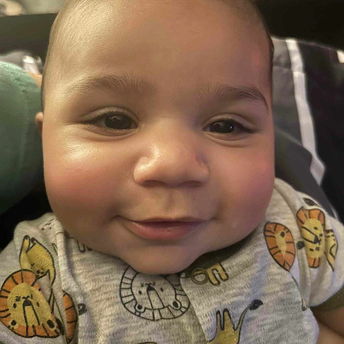 Kaleb joined the competition — help win amazing prizes! baby, bedding, cheeks, close_up, clothing, cute, expression, eyes, face, happy, head, indoor, infant, lion_print, onesie, pillow, portrait, skin, smiling, toy