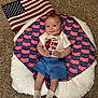 Finnley is registered to the contest to win money with this photo: baby, infant, american_flag, patriotic, blue_shorts, white_socks, carpet, cushion, smile, holding_flag, celebration, holiday, red_white_blue, cute, indoor, toddler, clothing, flag_pattern, happy, person
