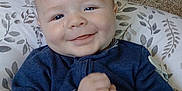 Finnley is registered to the contest to win money with this photo: baby, blue_clothing, carpet, casual, child, comfortable, cushion, cute, face, hands, happy, home, indoor, infant, patterned, person, portrait, sitting, smiling, young