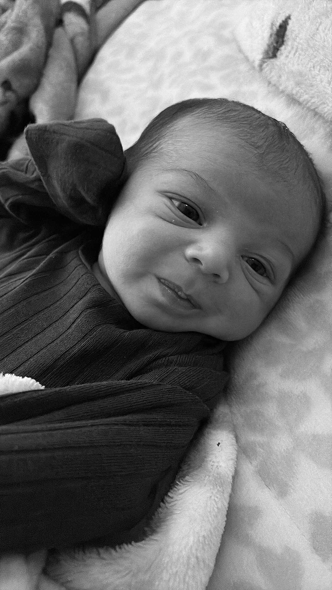 Zacheriah is registered to the contest to win money with this photo: baby, infant, face, portrait, black_and_white, blanket, clothing, newborn, cute, expression, soft, lying_down, texture, closeup, child, person, sleepwear, head, skin, babywear