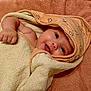 baby, towel, hood, smile, face, skin, arm, blanket, infant, cute, child, portrait, happy, eyes, wrapped, soft, cozy, newborn, babywear, lying_down