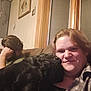 Dave is registered to the contest to win money with this photo: affection, beard, black_dog, casual, comfort, couch, cozy, dog, friendship, hair, home, indoor, person, plaid_shirt, relaxed, seated, smile, wall_art, window, wood_trim