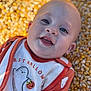 baby, blue_eyes, child, closeup, corn, corn_kernels, cute, face, ghost, halloween, happy, holiday, infant, orange_clothing, outdoor, portrait, pumpkin, seasonal, smile, white_clothing