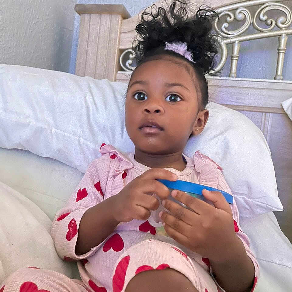 Harper is registered to the contest to win money with this photo: blackhair, child, clothing, curlyhair, face, female, girl, hair, head, knitting, mohawkhairstyle, person, sitting, sleeve, text, thermometer